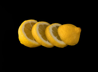 Lemon sliced in round slices on black background isolated
