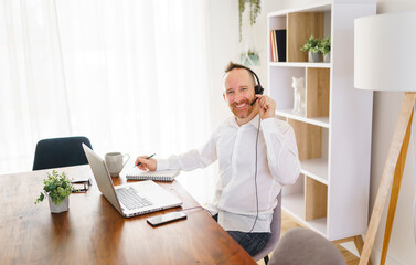 Nice mature man working on laptop at home