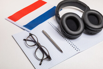Learning foreign languages in the Netherlands with audio recordings and headphones. Notepad, glasses, pen.