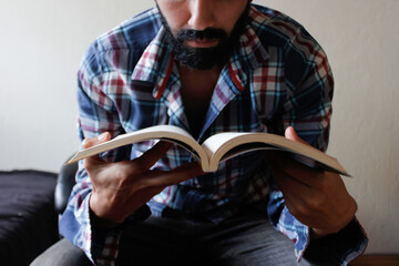 Hombre joven con barba leyendo
