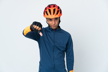 Young cyclist Brazilian man isolated on white background showing thumb down with negative expression