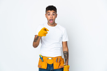 Young Brazilian electrician manipulated isolated on white background surprised and pointing front