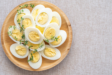 Boiled eggs on wooden plate over rustic background.