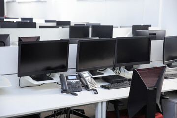 Workplace in the office with a computer monitor and telephone, without people.