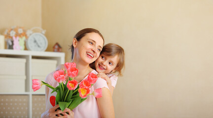 happy mother's day. baby daughter gives pink flowers to her mother for a holiday