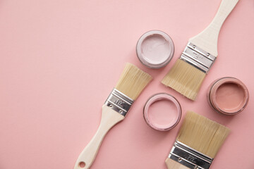 Overhead view of a DIY paint brush with pastel pink sample paint pots