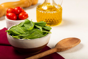 Arugula salad with tomatoes on white background.