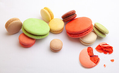Scattered different colors macarons on a white tablecloth