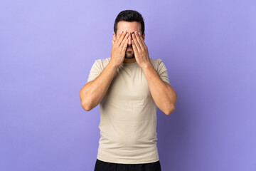 Young handsome man with beard over isolated background covering eyes by hands