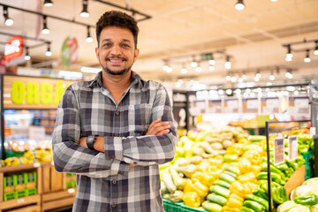 Latin American at the supermarket. Smiling man with arms crossed and looking at camera