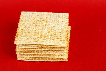 Matzo plates laid on top of each other on a red background.