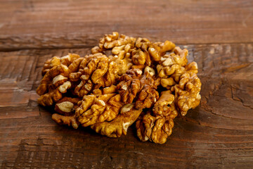 Walnuts are scattered on a dark wooden table.