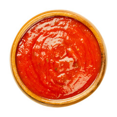 Tomato sauce with herbs, in a wooden bowl. 
Neapolitan sauce or salsa roja, made from tomatoes and herbs, cooked in olive oil. A vegan sugo, similar to ketchup. Close-up, over white, macro food photo.