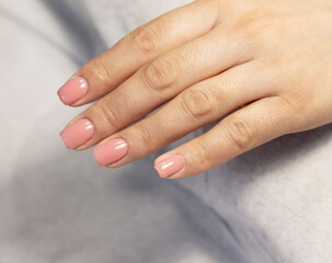 Manicure coating and strengthening of natural nails with artificial material gel in a beauty salon by a specialist. Close-up. Space for text
