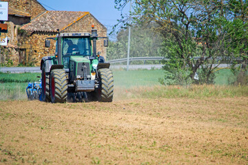 tractor plows a field on a farm in a village, agriculture