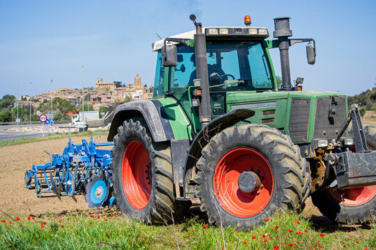 tractor plows a field on a farm in a village, agriculture