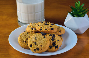 plate of chocolate chip cookies with a  glass of milk