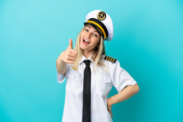 Airplane pilot over isolated blue background with thumbs up because something good has happened © luismolinero