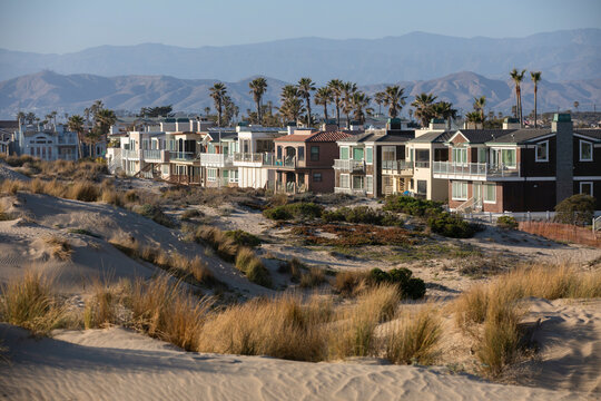 Sunset view of coastal dunes and houses in Oxnard, California, USA.