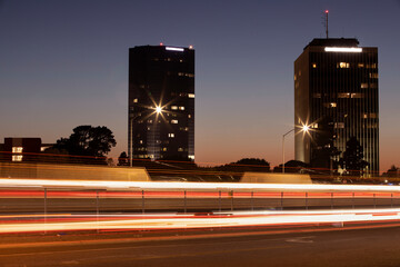 Traffic from the 101 freeway streams in front of the downtown skyline of Oxnard, California, USA.