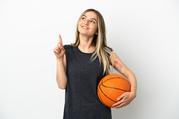 Young woman playing basketball over isolated white wall pointing up a great idea