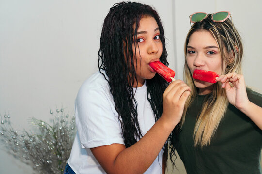 Two Friends Eating Ice Cream At Home. Two Women Enjoying A Popsicle