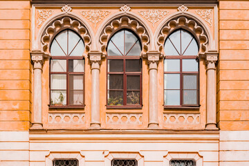 Antique baroque arch windows framed by decorative stucco. The facade of an old house. Architecture....