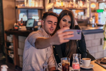 Front view of two business people making a selfie in the bar