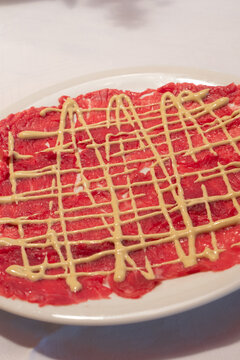 Beef Carpaccio with Mayonnaise Sauce in Classic Cipriani Style on a White Plate