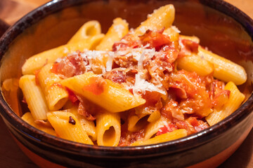 Penne all Arrabiata Pasta or Noodle Dish with Parmesan Cheese on a Rustic Table