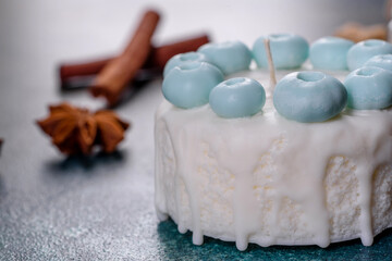 Beautiful colorful bright candle made in the form of an appetizing cake. Aromatherapy, candle with the smell of herbs