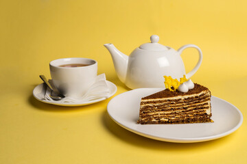 Delicious breakfast with the cake and black tea on yelow background. Top view. Copy space.