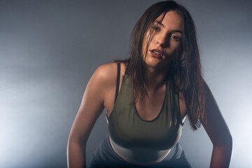 Photo with a smokey background of a confident young sporty girl with wet hair looking at the camera