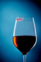 Glass with red wine and lipstick imprint of female lips