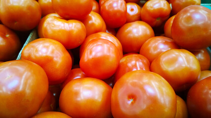 Fresh red tomatoes background. Vegetables in local farmers market or supermarket. Rich harvest. Products supply. Retail industry. Grocery store. Shop. Fresh organic food backdrop. Greengrocer. Crop