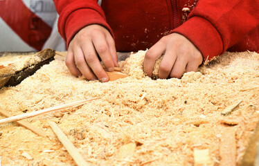 Child's hands on the background of a handful of dry technological chips. Selective focus. Remains...