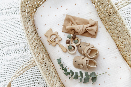 Baby basket with newborn items, booties and toys. Still life of child products. Newborn background. Minimalist style photography of baby shower, pregnancy announcement.