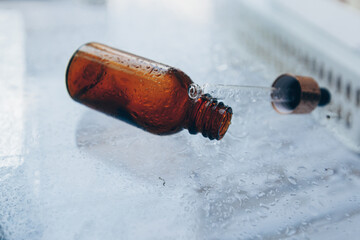 bottle and pipettes with hyaluronic serum for cosmetic and cosmetic procedures on glass with a...