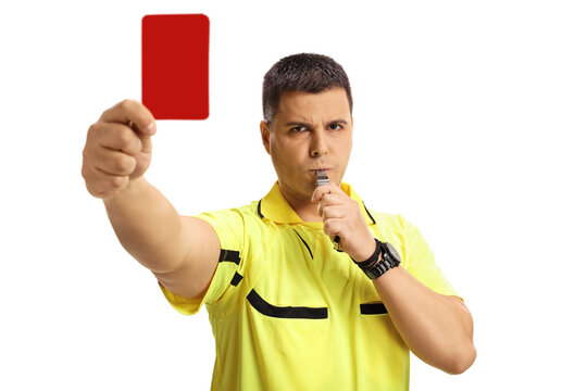 Serious football referee blowing a whistle and showing a red card
