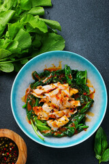 grilled squid with spinach and souce on dark background. ingredient of meal top view