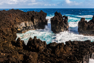 Fototapeta na wymiar Waves Crashing Against The Black Basalt Lava Shelf at Pakulua Point, Waianapanapa State Park, Maui, Hawaii, USA