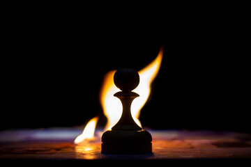 pawn on a chessboard on fire, foreground and background blurred