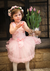 Close Up Portrait, 2 Years Old Toddler Girl with Big Blue Eyes, in light Pink Dress with Pink Flowers on her head, Sitting by the fireplace, Birthday Girl, Ukrainian Head bend, Little Princess 