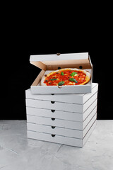 stack of pizza box delivery concept. pizza inside box and black background