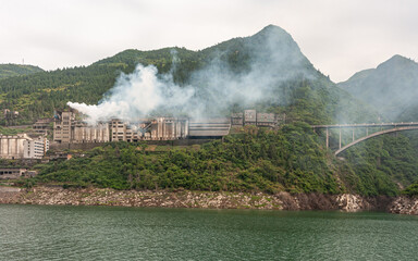 Yangtze River, Three Gorges, China - May 6, 2010: Xiling region. Smoking large cement factory set...