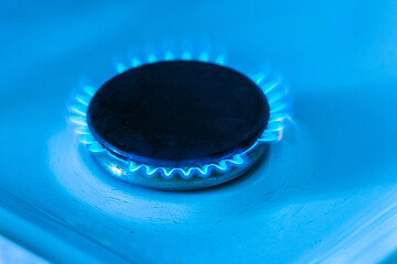 Gas burner with a blue flame on a gas stove, close-up