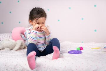Upset girl sitting on her bed..