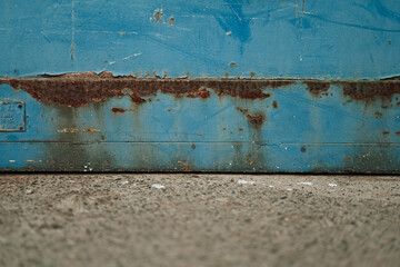 Industrial rust stained blue door and concrete floor