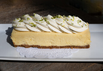 close up of a large slice of key lime pie with whipped cream and lime zest 