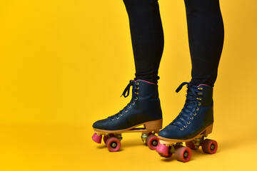 Girl legs using roller on yellow background.